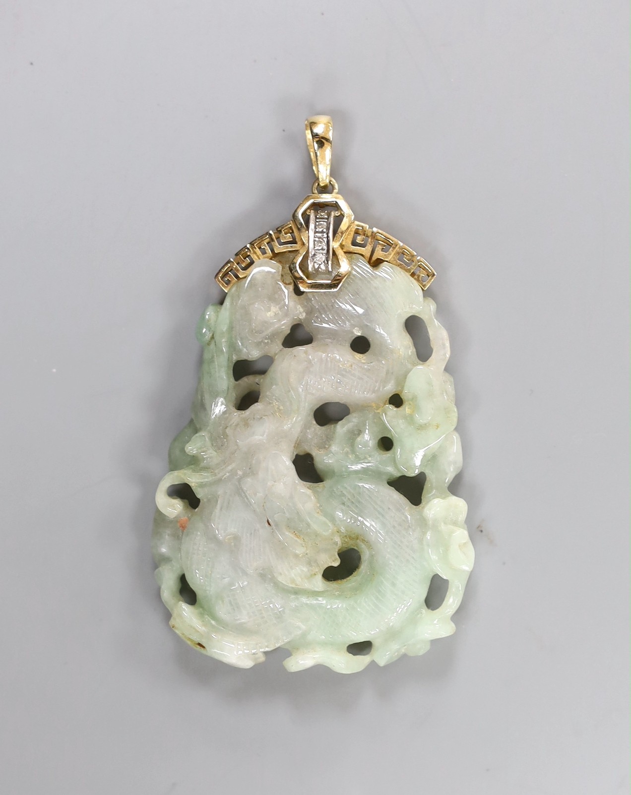 A Chinese jadeite Dragon pendant, the yellow metal mount stamped 14 K and set with diamond chips, overall 75mm, gross weight 31.4 grams.